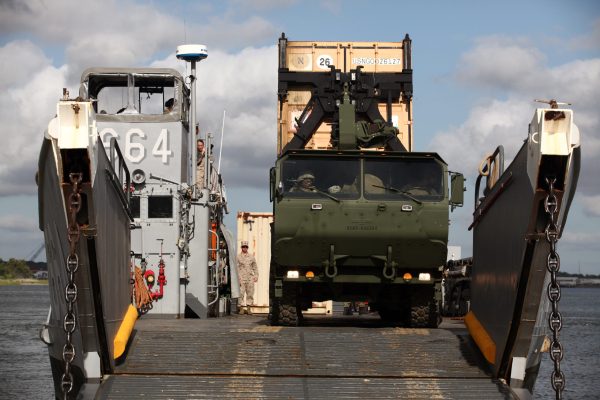 U.S. Marines from Combat Logistics Battalion 8, Transportation Support Company, work together with Navy personnel from Beach Master Unit 2 off-loading ISO containers off a Landing Craft Utility during the Expeditionary Logistics WarGame, on Joint Expeditionary Base, Little Creek, Va., June 15, 2012. The purpose of the mission is to build, sustain and enhance the Marine Corps interoperability with their sister services. (U.S. Marine Corps photo by Sgt. Anthony Ortiz/Released)