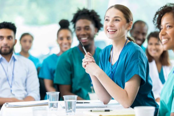 Cheerful Hispanic female nursing students smiles as she listens to a professor's lecture.